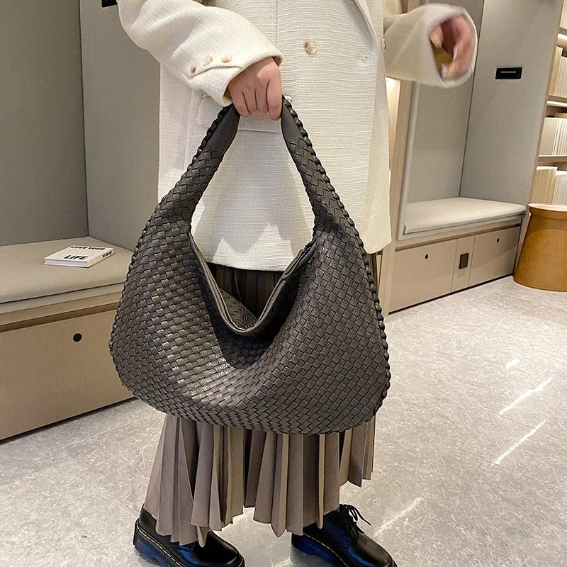 sac bandoulière femme cuir trissé porté dans main